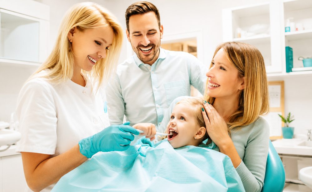 close up of a smiling patient during a routine dental checkup with warm soft lighting